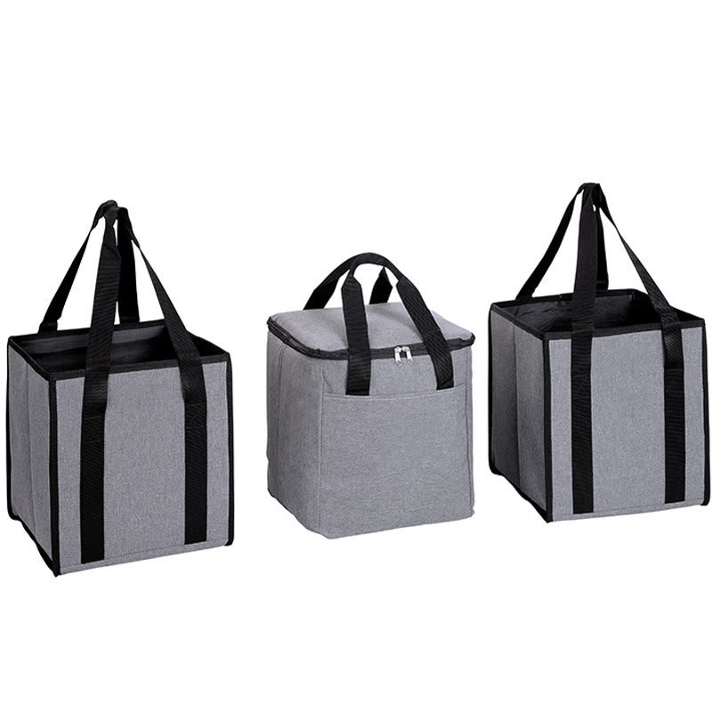 Insulated cooler carrier bags with black handles standing in a car boot